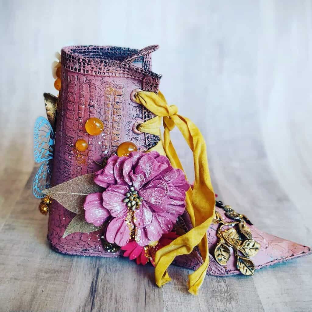 Zapato decorativo artesanal con flores y detalles en colores vibrantes.