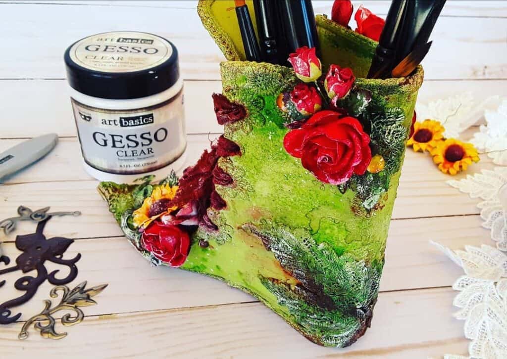 Jarrón decorativo artesanal con flores y materiales de manualidades, inspiración creativa perfecta.